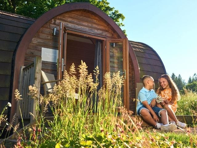 children sat outside a glamping pod at Whitemead
